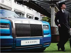  ??  ?? LONDON: An actor poses besides a Rolls Royce Waterspeed Phantom Drophead Coupe at the Bluebird Cafe in London.