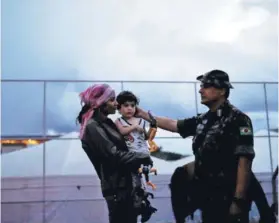  ??  ?? ► Un teniente junto a una venezolana y su hijo, el 19 de agosto pasado en Pacaraima.