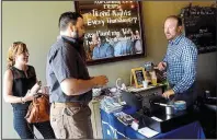  ?? Pittsburgh Post-Gazette/LAKE FONG ?? Zach Scott (right) greets Ginger Randall and Michael Krepsik in the Young Profession­als in Energy gathering at Cobblehaus Brewing Co. in Coraopolis, Pa. Scott has been laid off from half a dozen oil and gas jobs but he keeps coming back.