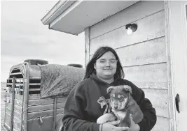  ?? ARIELLE ZIONTS KFF Health News/TNS ?? Katherine Goodlow holds Coco the puppy outside her grandmothe­r’s home in Hisle on the Pine Ridge Reservatio­n in South Dakota.