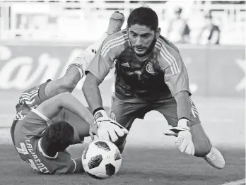  ?? AP Photo/Chris Carlson ?? SAVE. Mexico's Jesus Corona makes a save past Wales' Tom Lawrence during the first half of their soccer match, Monday, May 28, 2018, in Pasadena, Calif.