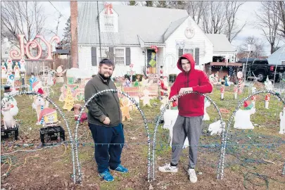  ?? PATRICK RAYCRAFT/HARTFORD COURANT ?? Joshua Brunelle, 21, at right, has hosted an annual holiday display that features more than 25,000 lights for the past seven years at his Plainville home. Edward Sedgwick-Cochran, 26, at left, is Brunelle’s chief helper. The display honors Brunelle’s late mother.