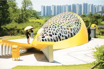  ?? WOOHAE CHO/THE NEW YORK TIMES ?? Visitors gather May 27 inside a memorial sculpture, in the shape of a yellow whale, at Danwon High School in Ansan, South Korea. The memorial honors the hundreds of students’ lives lost in the 2014 Sewol ferry disaster.