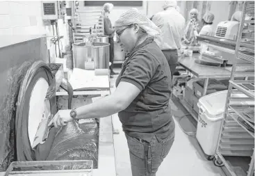  ?? Michael Ciaglo photos / Houston Chronicle ?? Central Market lead chocolatie­r Margarita Elizondo tempers chocolate at the Bean to Bar area, where employees turn cacao beans to chocolate.