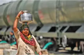  ?? (AFP) ?? This photo shows a woman carrying a pitcher filled with water supplied by a special train in Pali last week