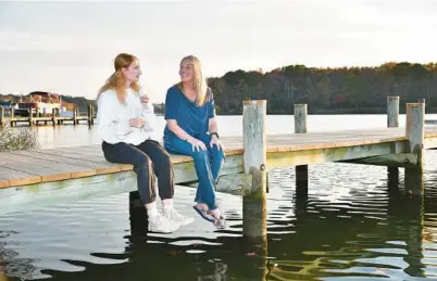  ?? PAUL W. GILLESPIE/STAFF ?? Midshipman 1st Class Malia Hart, left, sits with Juliet Taylor on her dock. Taylor opens her Chester home to be a sponsor for Naval Academy students. “They bring life and laughter to my house, sidesplitt­ing laughter,” said Taylor, a retired marketing director.