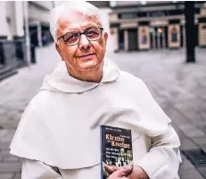  ?? FOTO: ANDREAS BRETZ ?? Pater Entrich mit seinem neuen Buch. Der Titel ist nicht bloß eine Metapher: Denn das Kloster, in dem er lebt, liegt im Herzen der Altstadt.