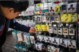  ?? MICHAEL NAGLE / BLOOMBERG FILE ?? A shopper browses fidget spinners displayed for sale by a street vendor in New York.