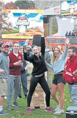  ?? MATT STONE / BOSTON HERALD ?? GAME ON! Boston College students David Pfalzgraf, Kyle Maloney, Natalie Donegan and Robyn Crowley enjoy ESPN’s “College GameDay” in Chestnut Hill before today’s big showdown against second-ranked Clemson. At right, “GameDay” sets up its stage.
