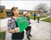  ?? U-T FILE ?? Elia Perez, food services manager at Harborside Elementary School in Chula Vista, directs cars to a food distributi­on line in March 2020.