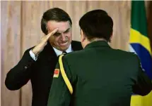  ?? Sérgio Lima - 8.mar.19/AFP ?? O presidente Jair Bolsonaro saúda militar chinês em evento no Palácio do Planalto