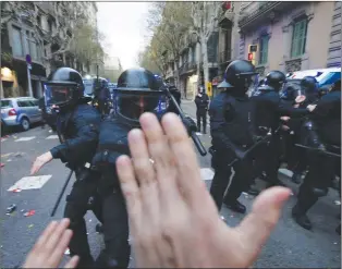  ??  ?? Catalan Mossos d’esquadra regional police officers clash with pro-independen­ce supporters trying to reach the Spanish government office in Barcelona, Spain, Sunday.