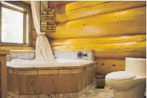  ??  ?? Looking bright and shiny, varnish was applied to the log beams inside the home to facilitate cleaning. In the main bathroom, a combinatio­n of larch wood and ceramic tiles was used for the sides of the bathtub and the floor.