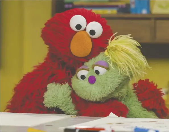  ?? Zach Hyman/Sesame Workshop ?? “I don’t have a place”: Sesame Street’s new character Karli, who is in foster care, gets a hug from Elmo.