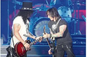  ??  ?? Guitarists Slash (left) and Fortus provided plenty of scorching solo moments that kept the crowd from burning out too early.