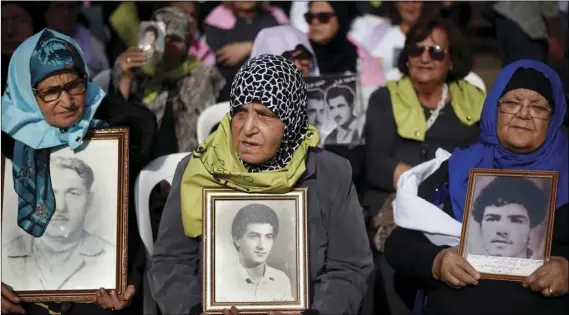  ?? AP PHOTO/BILAL HUSSEIN ?? Family members hold pictures of their relatives who went missing during the Lebanese 1975-90 civil war, during a press conference in front of the U.N. headquarte­rs in Beirut, Lebanon, on Wednesday.