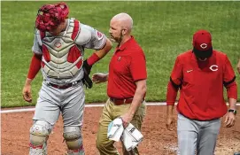  ?? GENE J. PUSKAR/ASSOCIATED PRESS ?? Cincinnati Reds catcher Tyler Stephenson, left, is helped by a team trainer as he leaves the team’s baseball game against the Pittsburgh Pirates with an injury during the third inning in Pittsburgh, Saturday.