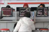  ?? LU QIJIAN / FOR CHINA DAILY ?? Investors check share prices at a securities brokerage in Fuyang, Anhui province.