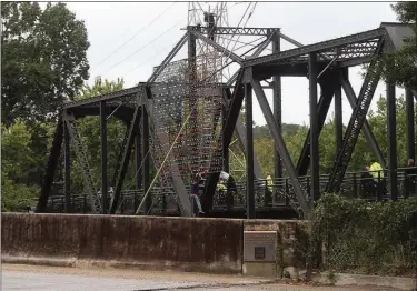  ?? Blake Doss /
Rome News-Tribune ?? Wendell Martin (near bottom of bridge) tries to climb down moments before he fell into the river Saturday. TOP: Martin sits on top of the bridge. BELOW: Firefighte­rs Sgt. Mark Jenkins, Cody Benton and Matt Aultman take Martin to safety after rescuing...