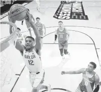  ?? GREGORY SHAMUS/GETTY ?? Jared Butler soars above the Wisconsin defense for a dunk during Baylor’s second-round victory Sunday.