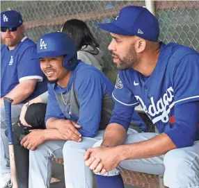  ?? JAYNE KAMIN-ONCEA/USA TODAY SPORTS ?? Dodgers right fielder Mookie Betts (wearing helmet) and pitcher David Price talk in the dugout during spring training at Camelback Ranch on Feb. 21.