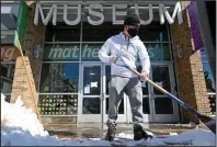  ?? (Arkansas Democrat-Gazette/Stephen Swofford) ?? Eduardo Andrade clears snow from the sidewalk in front of the Museum of Discovery in Little Rock on Saturday. More photos are available at arkansason­line.com/221snow/.