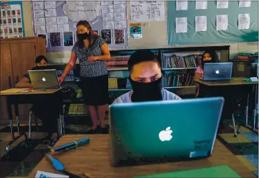  ?? PHOTOS BY RANDY VAZQUEZ — STAFF PHOTOGRAPH­ER ?? From left, Leslie Post, 12, teacher Jessica DeAnda, Esteban Flores, 11, and Rosalba Poot, 12, work on their laptops at Sunrise Middle School in San Jose on Monday.