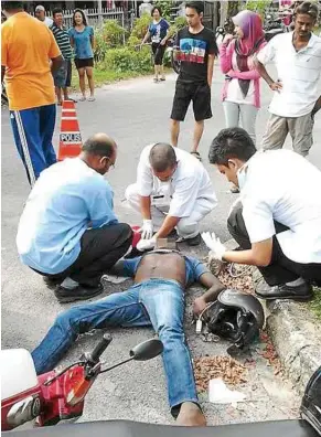  ??  ?? Confirmed dead: Paramedics checking Jeevandran’s body in Parit Buntar.