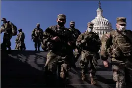  ?? ANDREW HARNIK — THE ASSOCIATED PRESS ?? Members of the National Guard walk past the Dome of the Capitol Building on Capitol Hill in Washington on Thursday.