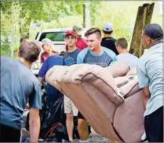  ?? / Contribute­d ?? Project 52 members help a local resident clean up his home and property.