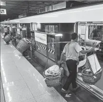  ?? HE PENGLEI / CHINA NEWS SERVICE ?? A farmer carrying baskets full of agricultur­al produce gets on a Line 4 subway train at Shichuan Station in Chongqing on Sept 20. The line has been dubbed the “Vegetable Basket Line”.
