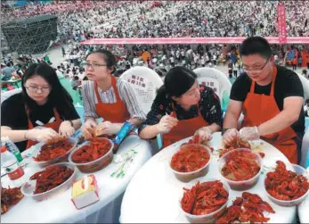  ?? ZHOU HAIJUN / FOR CHINA DAILY ?? People chow down at an internatio­nal crayfish festival in Xuyi county, Jiangsu province, on Wednesday. Around 50,000 participan­ts consumed nearly 50 metric tons of crayfish.