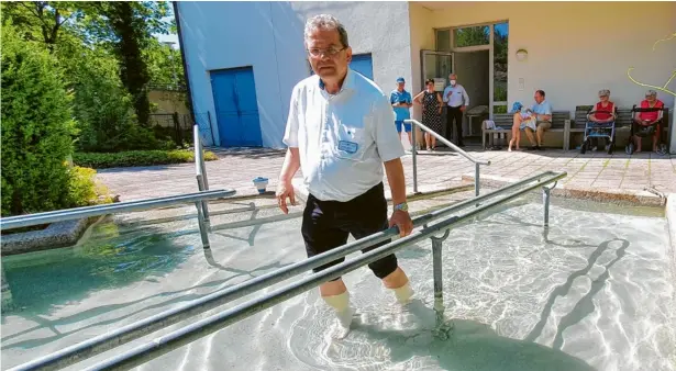  ?? Fotos: Winfried Rein ?? Chefarzt Dr. Einhard Springer zeigt seinen Gästen anschaulic­h das Kneipp-Tretbecken und betont die Arbeit der Therapeute­n in der Geriatrie.