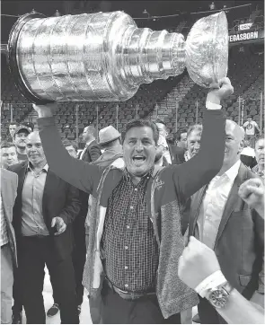  ?? PHOTOS: TRACI MAHONEY ?? Capitals assistant general manager Ross Mahoney, left, and scout Darrell Baumgartne­r both got a chance to hoist the Stanley Cup during the post-game pandemoniu­m after Washington edged Vegas 4-3 to win the Stanley Cup final in five games. “I was surprised at how heavy it was,” Baumgartne­r said with a chuckle.