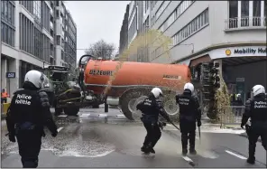  ?? (AP/Harry Nakos) ?? Farmers spray police with manure during a protest Monday in the European Quarter outside a meeting of EU agricultur­e ministers in Brussels.