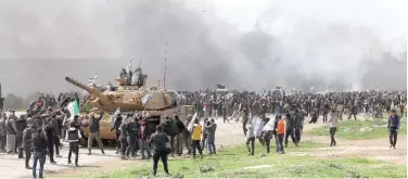  ?? Reuters ?? ↑
People hold Syrian opposition flags during a protest at the M4 highway in Idlib on Sunday.