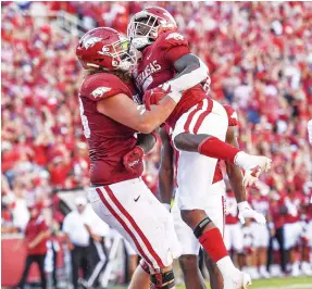  ?? (Hank Layton) ?? Arkansas offensive lineman Dalton Wagner (left) lifts running back Raheim Sanders during a game against Alabama. Wagner has become one of the Razorbacks’ top offensive players this season.