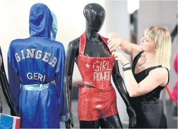  ??  ?? ABOVE A woman adjusts a costume display at the Spice Girls Exhibition in London.