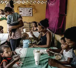  ?? Meridith Kohut/The New York Times ?? Em uma cena cada vez mais rara, crianças venezuelan­as são alimentada­s em La Guaira; falta de merenda nas escolas é apontada por relatório de comissão