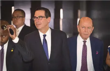  ??  ?? US Treasury Secretary Steven Mnuchin (left) and US Commerce Secretary Wilbur Ross (right) walk through a hotel lobby as they head to the Diaoyutai State Guest House to meet Chinese officials for ongoing trade talks in Beijing. — AFP photo