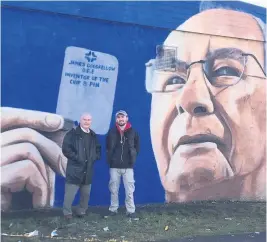  ??  ?? Off the wall Artist Shaun Devenney and his mural of James Goodfellow, the Paisley man who invented the PIN number