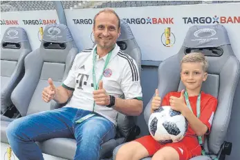  ?? FOTO: HEIKO SAUTER ?? Das Balltragek­ind des DFB-Pokalfinal­es Bastian Fischer gemeinsam mit seinem Papa auf der Auswechsel­bank im Olympiasta­dion in Berlin.