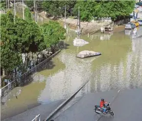  ?? (Foto BERNAMA) ?? Keadaan sekitar Jalan Mawar di Shah Alam yang masih ditenggela­mi air akibat limpahan dari Sungai Damansara. Pembanguna­n tidak terancang dikatakan menjadi punca sistem saliran tidak direka bentuk dengan sempurna.
