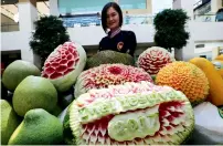  ??  ?? A visitor admires the fruit carvings on display at the festival.