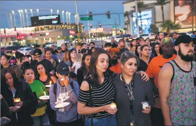  ?? DREW ANGERER / GETTY IMAGES VIA AFP ?? Mourners attend a candleligh­t vigil at the corner of Sahara Avenue and Las Vegas Boulevard on Monday for the victims of Sunday night’s mass shooting in Las Vegas, Nevada.