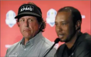  ?? MATT SLOCUM — THE ASSOCIATED PRESS FILE ?? Phil Mickelson, left, listens to Tiger Woods speak during a news conference in which they were announced as captain’s picks for the 2018 U.S. Ryder Cup Team. Woods and Mickelson have combined for 124 wins on the PGA Tour, and Mickelson believes they’re not done.