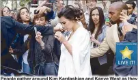  ??  ?? People gather around Kim Kardashian and Kanye West as they leave their residence in Paris on Friday.
AFP