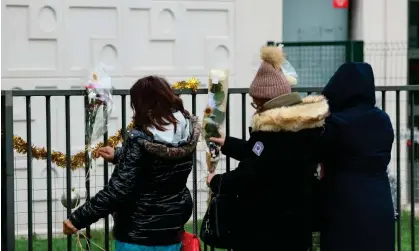  ?? Alain Jocard/AFP/Getty Images ?? People place flowers in front of the ground-floor flat in Meaux where the bodies of the woman and four children were found. Photograph: