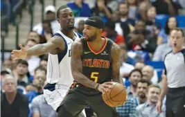  ?? AP Photo/LM Otero ?? Atlanta Hawks guard Malcolm Delaney (5) looks to pass against Dallas Mavericks forward Harrison Barnes during the first half of an NBA basketball game Wednesday in Dallas.