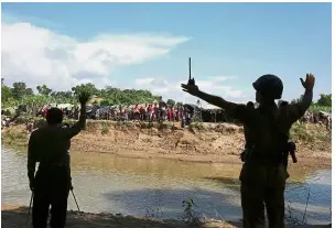  ?? — AP ?? file photo showing Bangladesh­i border guards gesturing to Rohingya who are stuck in the ‘no man’s land’ in Tombru.